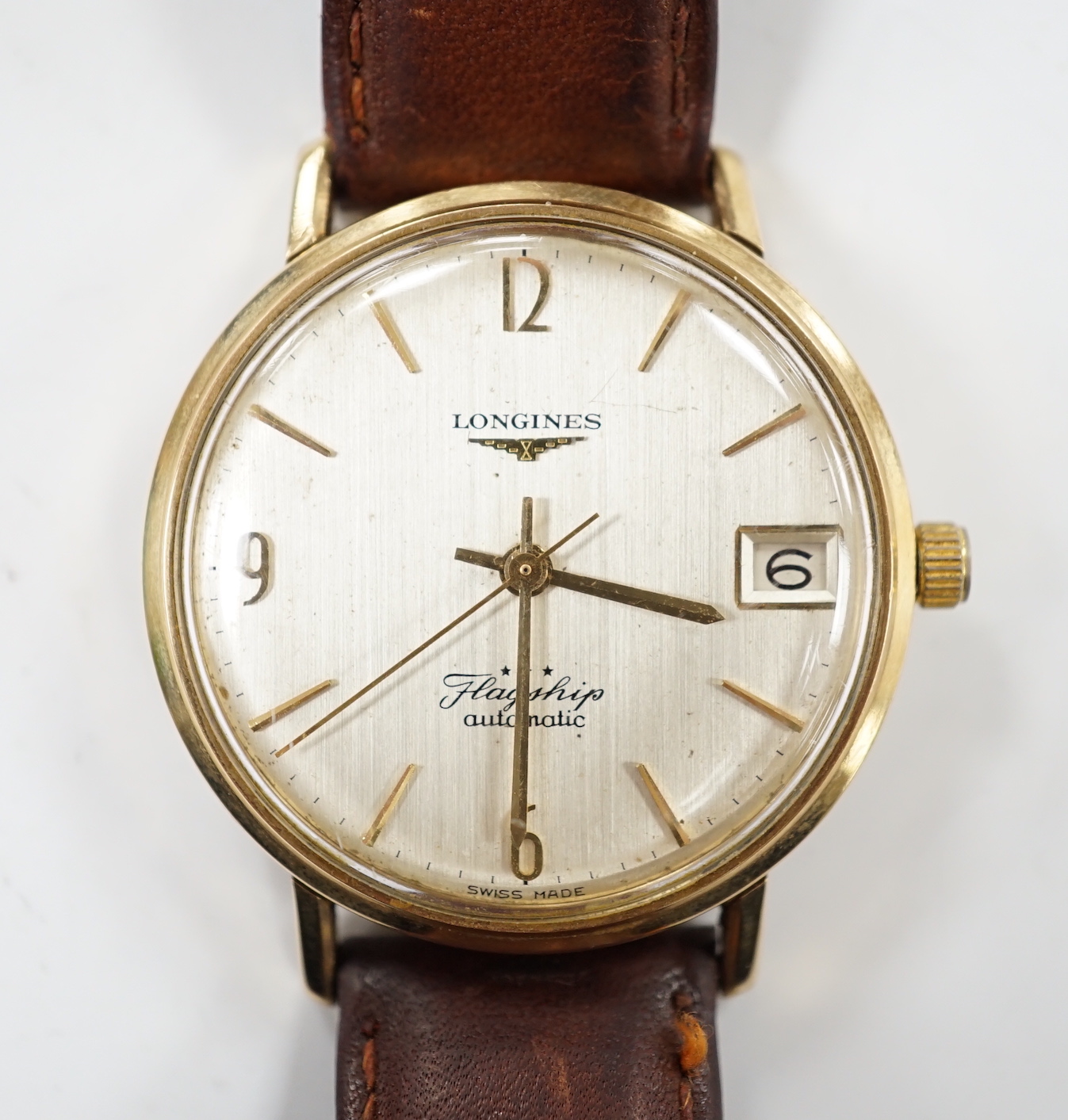A gentleman's 9ct gold Longines Flagship automatic wrist watch, with baton numerals and date aperture, on associated leather strap.
